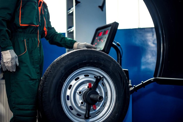 A male mechanic using a balancing machine before reporting to Vehicle Maintenance Reporting Standards (VMRS).